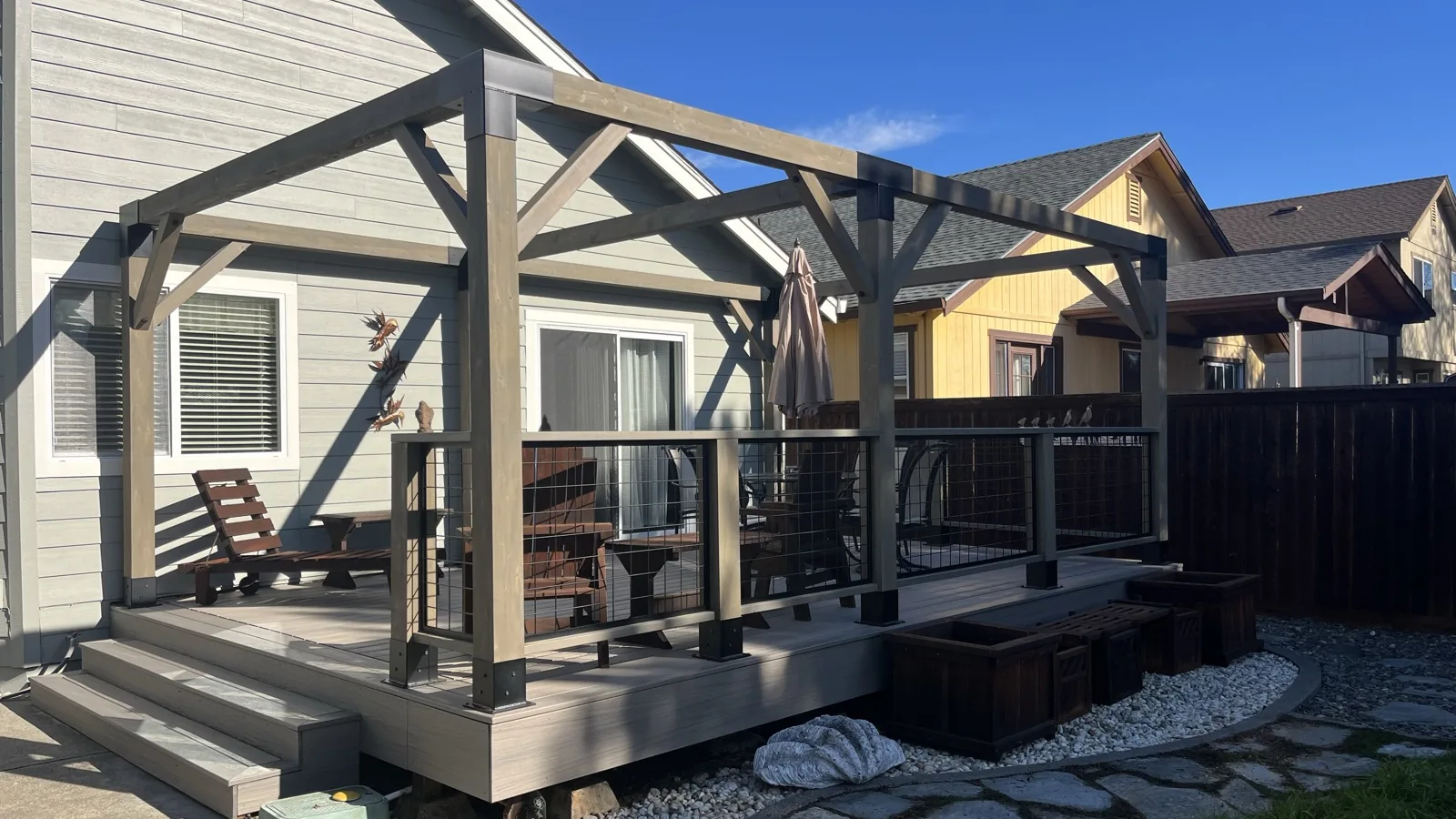 Custom composite deck with a timber-frame covered pergola and cable railing, built by Soulié Construction in Sonoma County