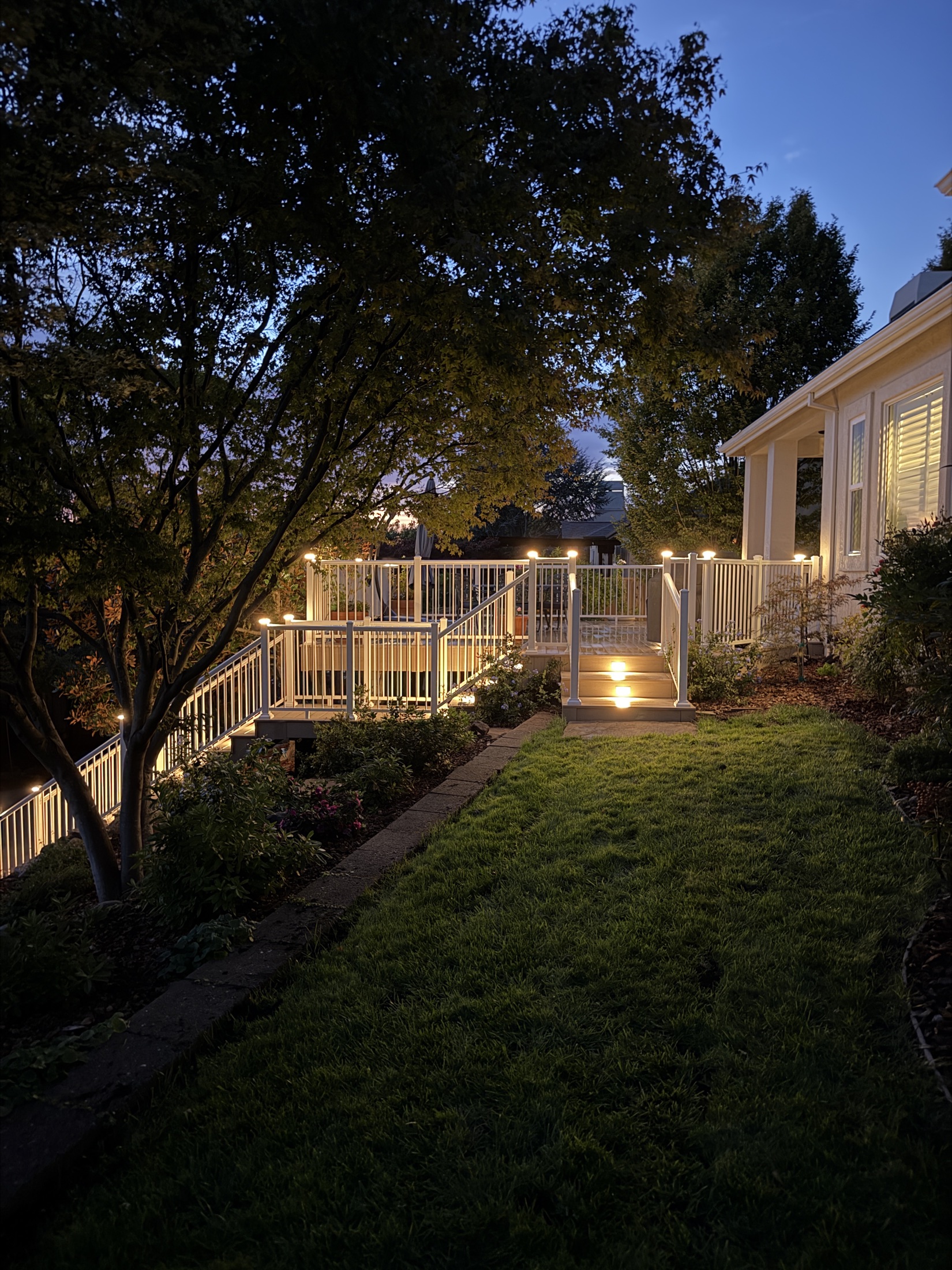 Illuminated custom deck and outdoor living space at dusk — Soulié Construction, Sonoma County