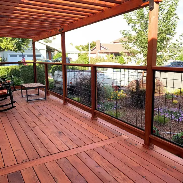 Finished redwood deck with wood pergola roof and Wild Hog metal railing panels at a Petaluma home