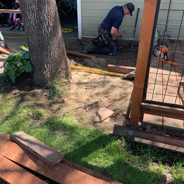 Carpenter framing a wood deck expansion around an existing tree trunk in Santa Rosa
