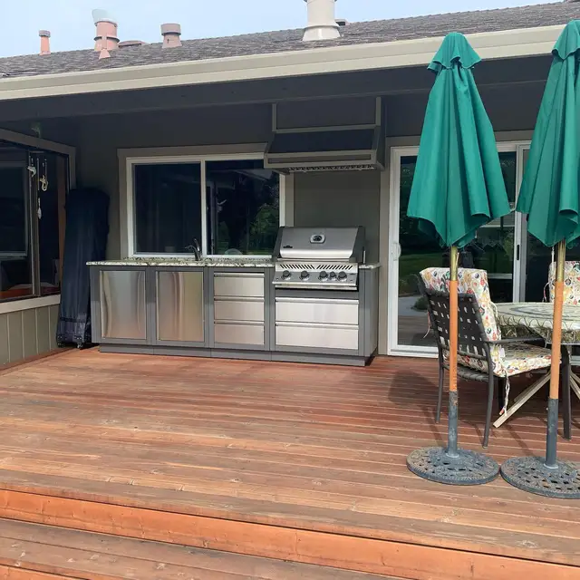 Stainless steel outdoor kitchen with granite countertop and built-in grill on a redwood deck in Santa Rosa