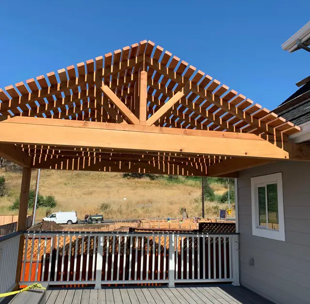 Gable-style redwood pergola with slatted rafters over a Trex composite deck in Santa Rosa