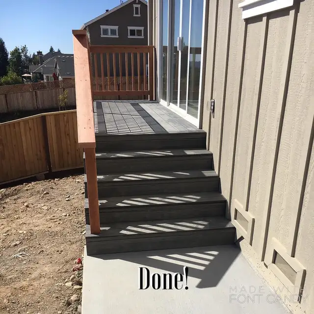 Completed composite deck landing and wood-framed stairs with railing off a sliding glass door in Santa Rosa